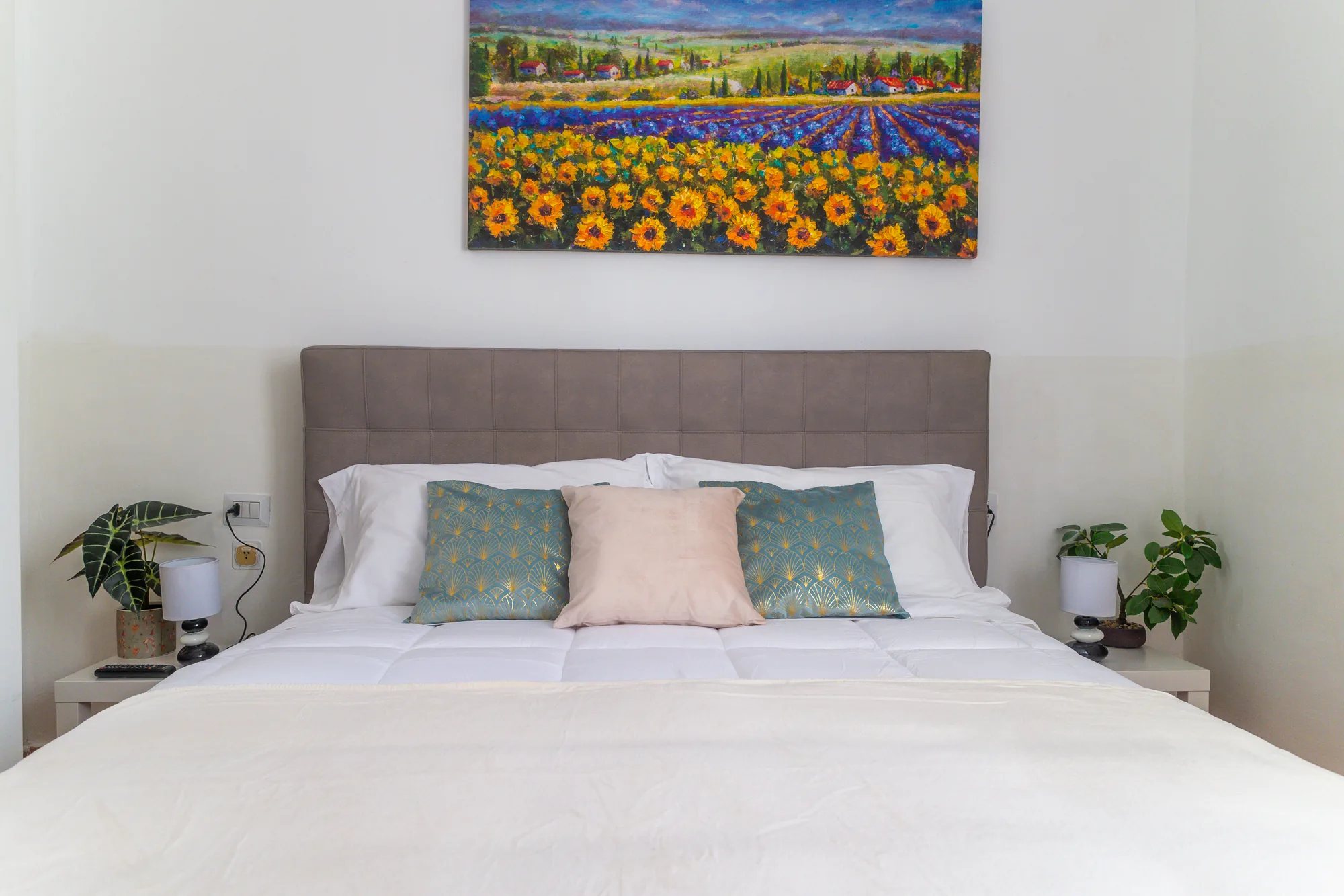 Camera matrimoniale con letto queen e quadro dei girasoli